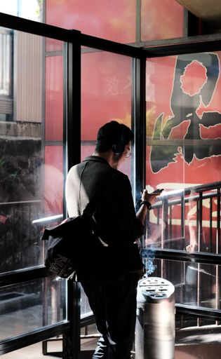 A vertical shot of a man smoking inside a mall room in Shinagawa, Tokyo