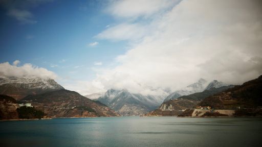 An aerial shot of a beautiful lake near the mountains on a sunny day