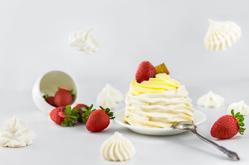 A cream muffin with strawberry and cracker isolated on a blurred background
