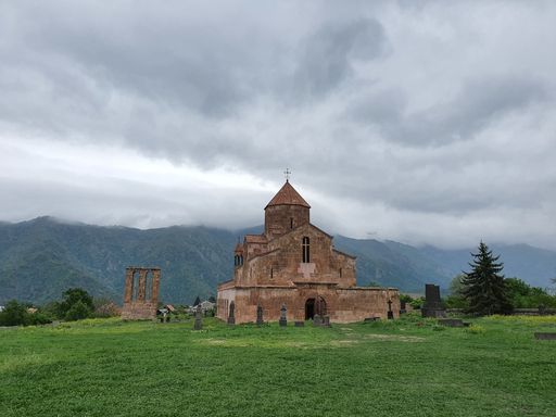A wide angle shot of the church in Odzun, Armenia under a clouded sky