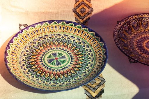 The big colorful plates on a table with a white tablecloth