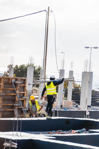 A photo of workers working on a construction settlement in the street