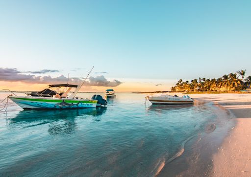 Sandy Beach on Mauritius in the Indian Ocean illuminating two boats peacefully parked in the blue, turquoise sea, and boot