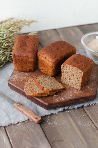 A bunch of loaf bread on a wooden tray with yeast