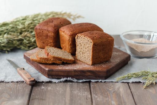 A bunch of loaf bread on a wooden tray with yeast