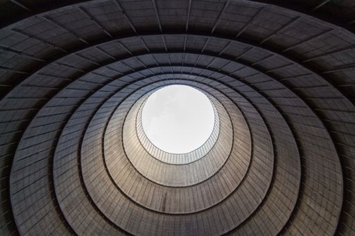 Inside a cooling tower of a nuclear power plant. View upwards, sky with haze. abandoned place
