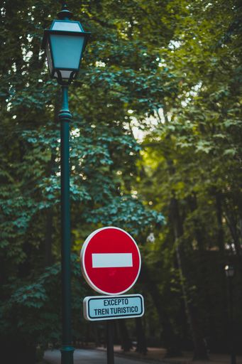 A vertical shot of a red don't enter sign on a park entrance