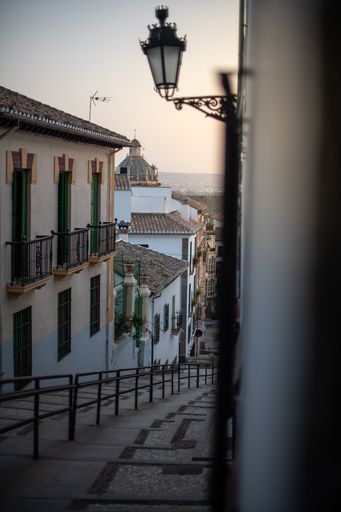 A vertical shot of an old city houses near a big stone staircase
