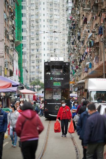 A vertical shot of the busy traffic and a crowded road with tall buildings in Hong Kong