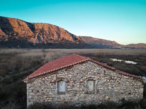 A house in the middle of nowhere in the background of mountains