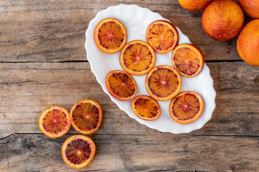 A closeup of sliced red oranges on a white plate