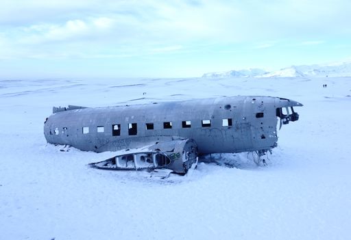A closeup of a ruined plane on the snow with blue sky background