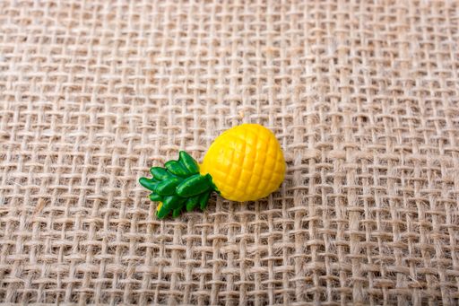 A single pineapple toy on a textured surface