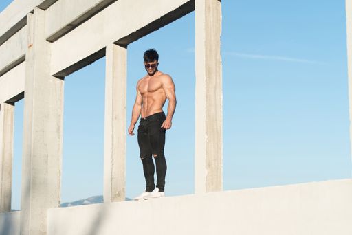 Handsome Man Standing Strong and Posing at Outdoors Wearing Black Jeans - Background of Sky