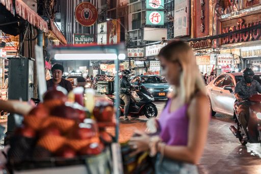 A female buying street food in China Town,  Bangkok, Thailand