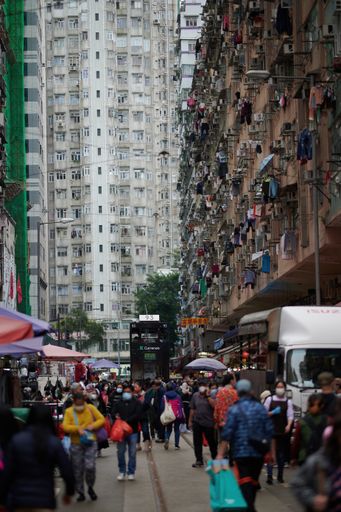 A vertical shot of crowded road with tall buildings in Hong Kong