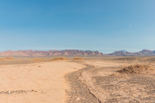 A beautiful shot of a brown desert and rocky cliffs in the rural area of Western China
