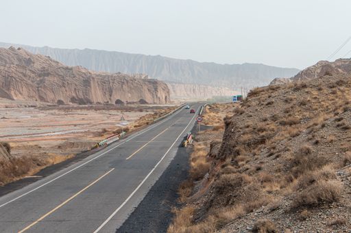 A long road going through rocky cliffs in the rural area of Western China