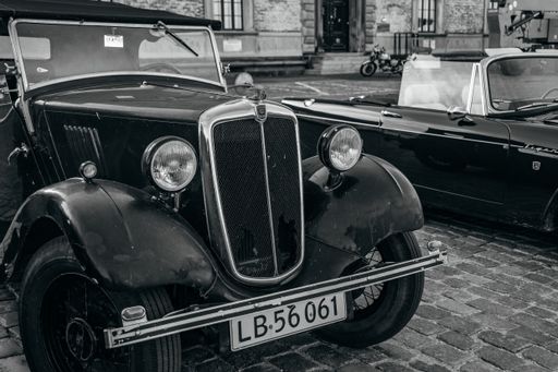 A  grayscale shot of the exhibition of old vintage cars in the streets of Copenhagen, Denmark