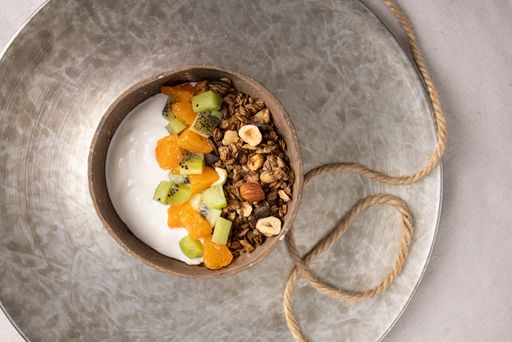 A Top view of a plate of granola with fruits and white yogurt, breakfast idea