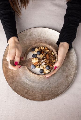 A Top view of a plate of granola with fruits and white yogurt, breakfast idea
