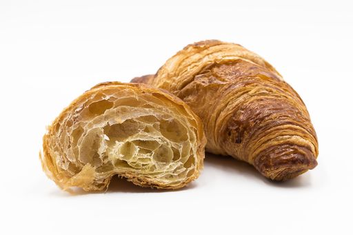 A closeup shot of a croissant cut in half isolated on a white background