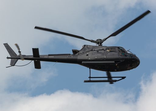 A low-angle shot of a Helicopter of Heli Dubai  tours flying against the blue sky
