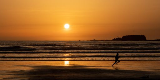 A person running along the beach at sunset, Long Beach, Tofino