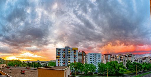 A landscape shot of buildings with a background of a cloudy pink sky