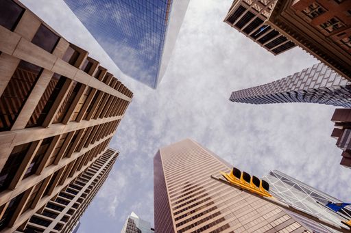 A low angle shot of high skyscrapers buildings towers in Calgary, Canada against a cloudy blue sky