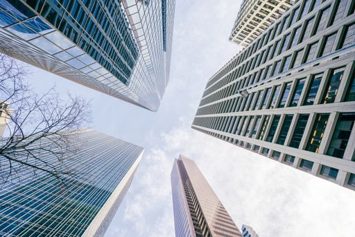 A low angle shot of high skyscrapers buildings towers in Calgary, Canada against a cloudy blue sky