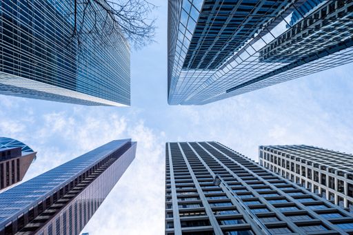 A low angle shot of high skyscrapers buildings towers in Calgary, Canada against a cloudy blue sky