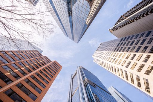 A low angle shot of high skyscrapers buildings towers in Calgary, Canada against a cloudy blue sky