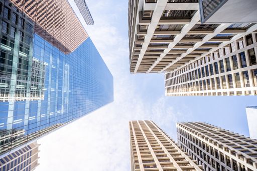 A low angle shot of high skyscrapers buildings towers in Calgary, Canada against a cloudy blue sky