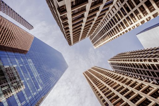 A low angle shot of high skyscrapers buildings towers in Calgary, Canada against a cloudy blue sky