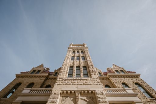 A low angle shot of the Calgary city hall building against a sunny blue sky in Canada