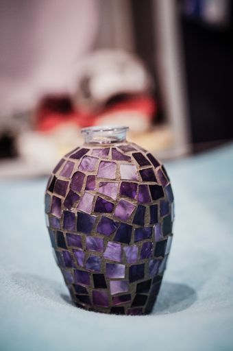 A vertical shot of a purple mosaic vase on a soft towel