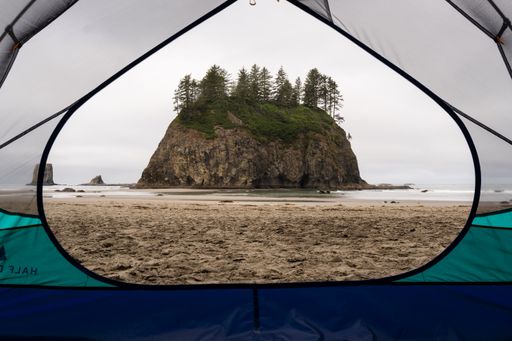 A sea stack on the coast of Washington state viewed through the open window of a tent