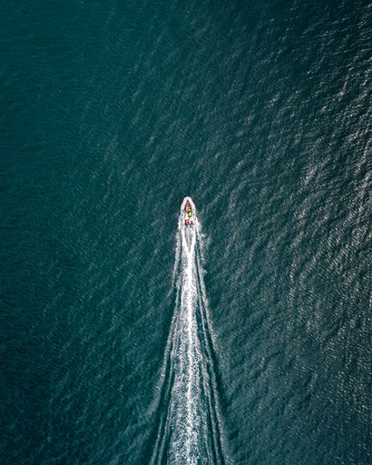 A vertical top view of a boat sailing through Elliot Bay in Seattle, Washington