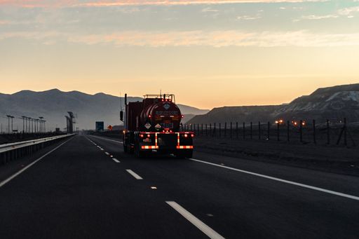 A truck on the road in the desert during sunset