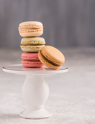A vertical shot of colorful gourmet macarons on a stand