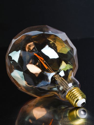 A closeup of a creative light bulb on a black background