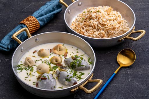 A closeup of a plate of rice with a plate of dumpling with sauce