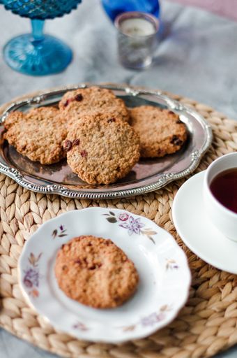 A closeup shot of fresh sweet cookies with jam on a table with a cup of tea in bakery house