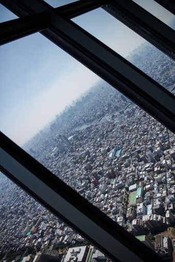 A vertical birds-eye view of a city from the skyscraper glass window