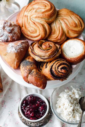 A Top view of fresh baked sweet buns with sugar powder on a white plate on a table