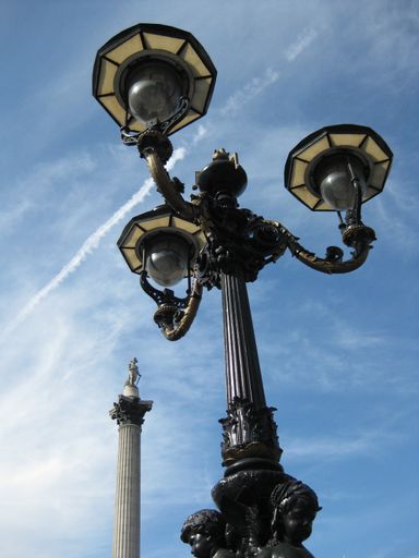 A low angle vertical shot of a street post lamp with a blue sky in the background