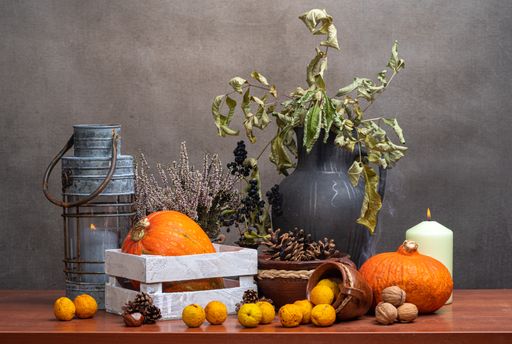A closeup shot of fruits, flowers, vasesas a still life