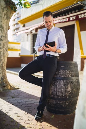 A successful young businessman in a formal outfit using a tablet