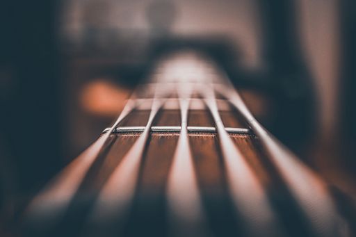 A closeup shot of a bass guitar strings against a blurred background